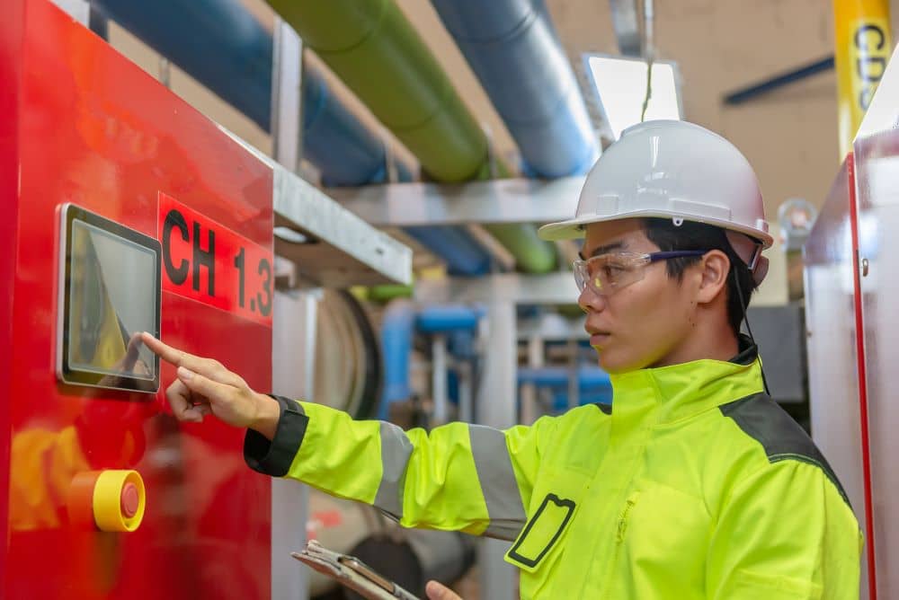 Asian engineer wearing glasses working in the boiler room,maintenance checking technical data of heating system equipment,Thailand people